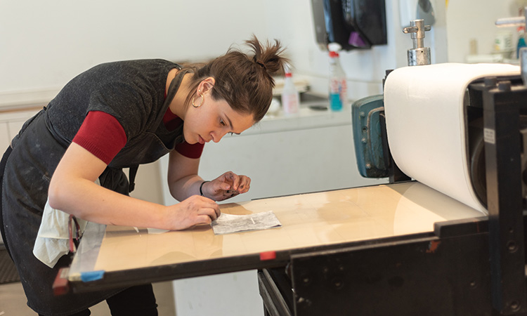 A student works with a press.